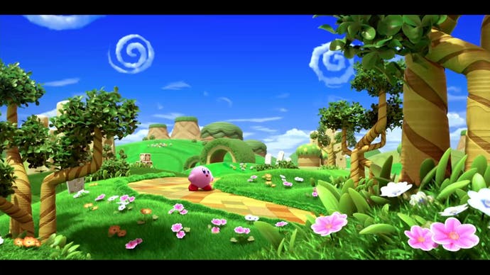 2022 best games Kirby and the Forgotten Land - Kirby on a yellow right in a very bright land of green grass, pink flowers and blue skies