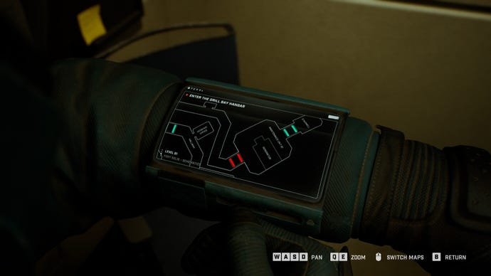 A close-up of the player's wrist-mounted computer in Fort Solis, showing the wireframe 2D map screen.