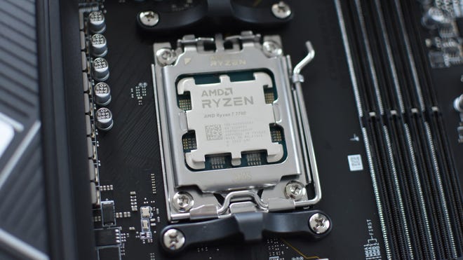 An AMD Ryzen 7 7700 CPU installed in a motherboard's AM5 socket.