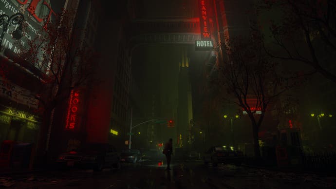 Alan Wake 2 screenshot showing Wake's distant silhouette in a rainy street, at night, through a dark city with red neon lights