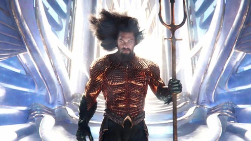 Aquaman in front of a bright throne