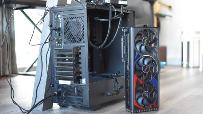The Asus ROG Strix GeForce RTX 4080 OC Edition graphics card propped up next to a PC case.