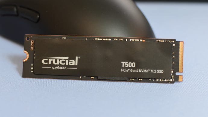 The Crucial T500 SSD propped up against a gaming mouse.