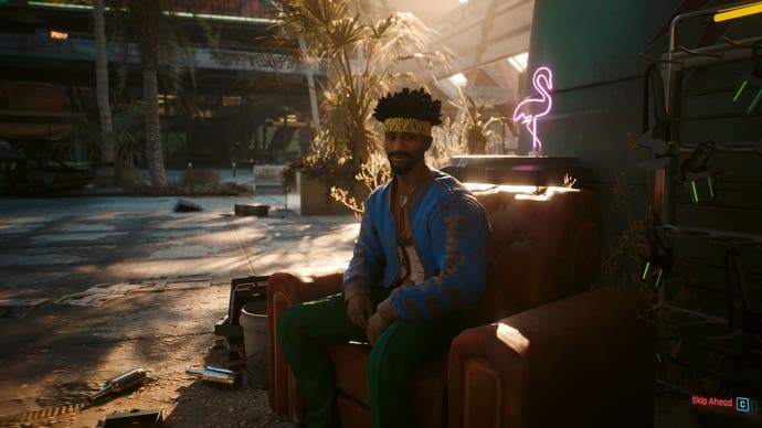 Capture d'écran de Cyberpunk 2077 Phantom Liberty montrant quelqu'un assis sur un canapé dehors à Dogtown