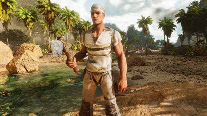 A screenshot from Ark: Survival Ascended showing the player character stood on a rock in the middle of a river, facing the camera with an axe in his hand.