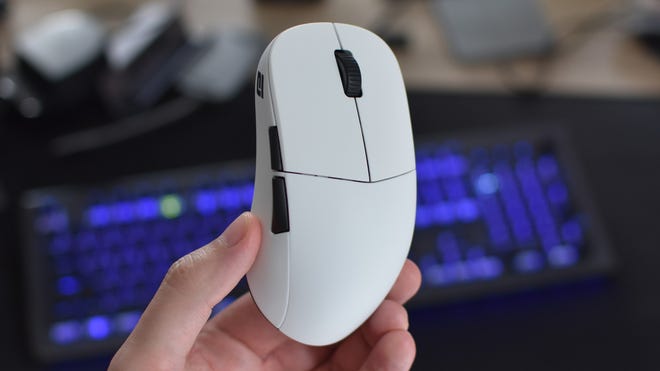 A hand holding up the Endgame Gear XM2WE gaming mouse.