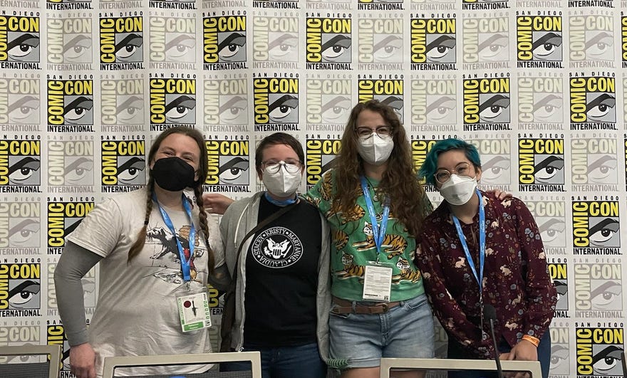 Image of Raina Telgemeier, Katy Farina, and Gale Galligan standing in front of SDCC banner