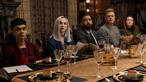 Several characters from Fall of the House of Usher sitting at a table.