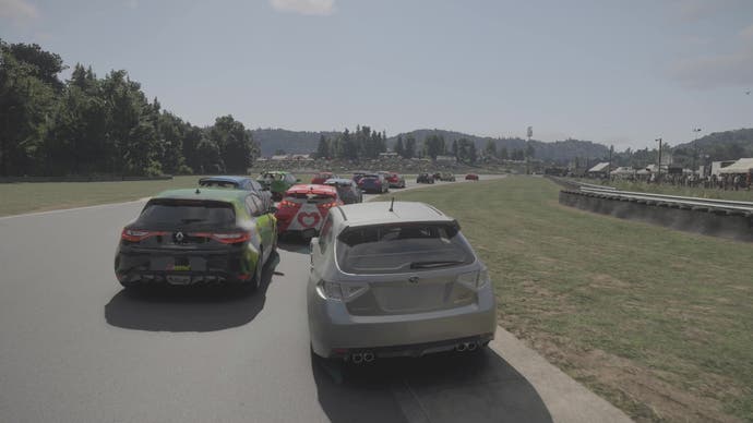 Captura de pantalla de Forza Motorsport, que muestra una corriente de autos que reducen la velocidad al tomar una curva, con árboles al fondo.