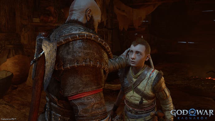 God of War preview - Kratos talks to Atreus, cupping his head with his left hand