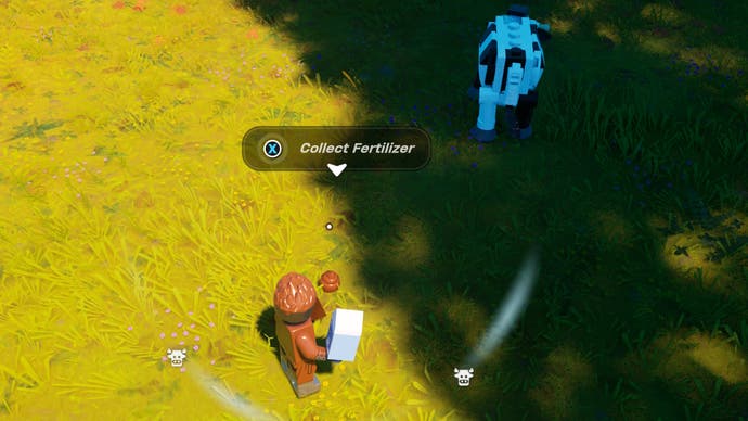 cropped view of a lego figure looking at fertilizer in a field near a cow
