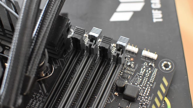 Step 2 of how to install RAM: identify the correct RAM slots to use, then open their plastic retention clips.