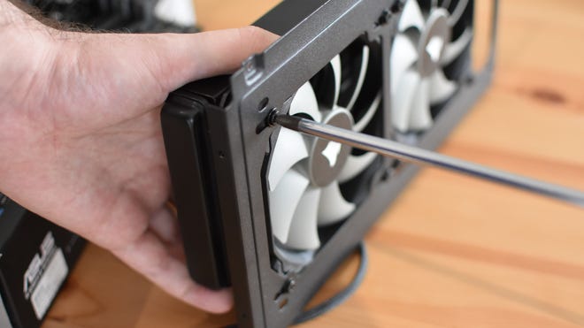 Step 6 of how to install a CPU liquid cooler: assemble the radiator and fans and mount both to the PC chassis.