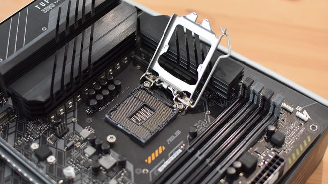 Step 1 of how to install a CPU: Open the metal cover over the motherboard's CPU socket.