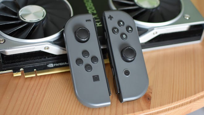 A set of Nintendo Joy-Cons laying against an Nvidia graphics card.