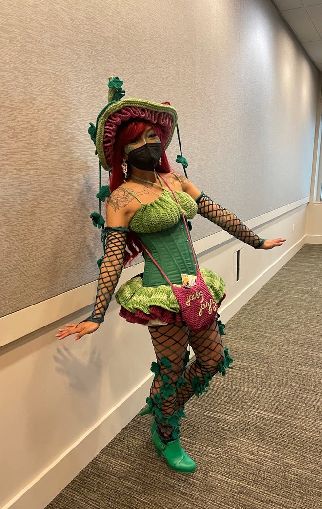Jae wearing her Poison Ivy costume against a tan wall