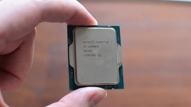 An Intel Core i9-12900KS CPU being held between a finger and thumb.