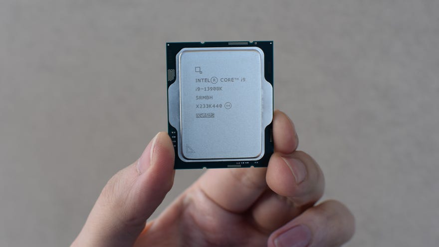 An Intel Core i9-13900K CPU being held between fingers.