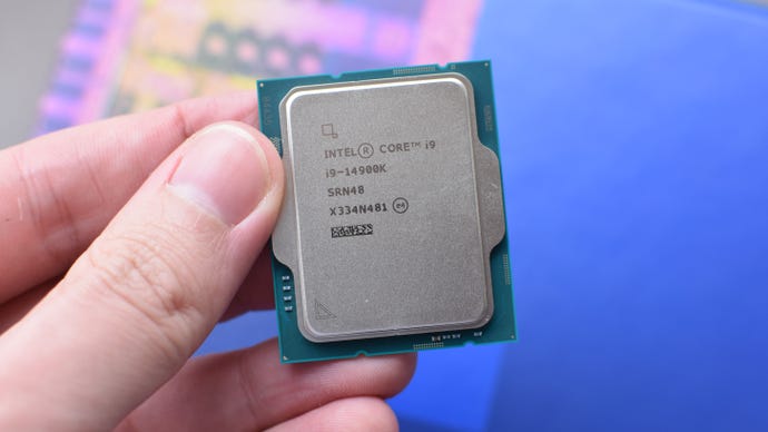 An Intel Core i9-14900K CPU being held between a finger and thumb.