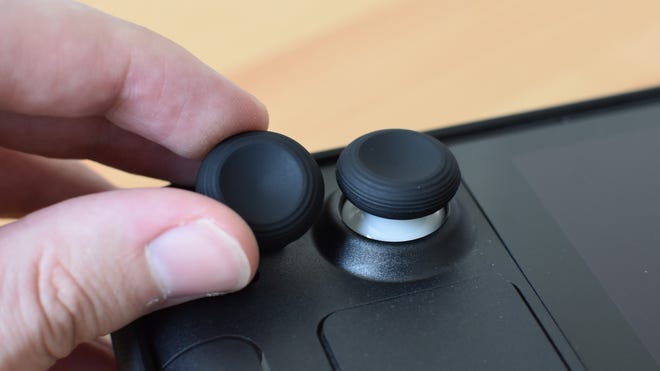 Die Jsaux Steam Deck Thumb Grip Caps. Eine wird auf das Dampfdeck angewendet