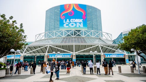 An outdoor photo of LA Comic Con featuring a banner and people