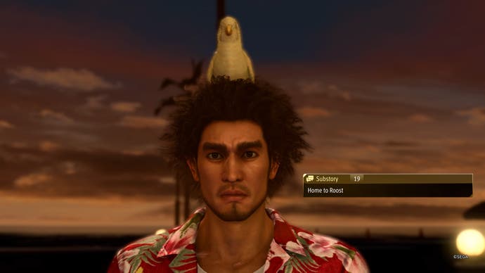 Screenshot from Like A Dragon: Infinite Wealth, showing a baby chick nesting in Ichiban’s hair.