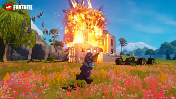 A screenshot from Lego Fortnite showing a building exploding with bricks flying out.