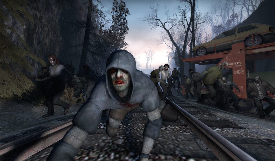 Hooded zombie crouches on train tracks in front of an undead horde in left 4 Dead screenshot.