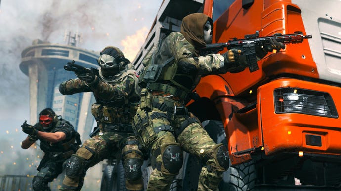 Modern Warfare 2 image showing Task Force 141 in cover behind a large orange truck, with a smoking tower in the background.