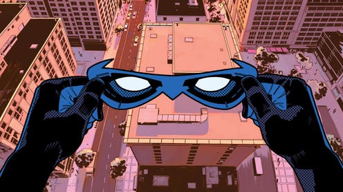Nightwing holds his mask