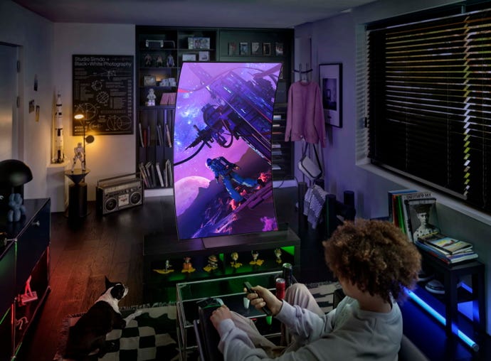 A young person pretends to play a game in portrait mode on the Samsung Odyssey Ark gaming monitor