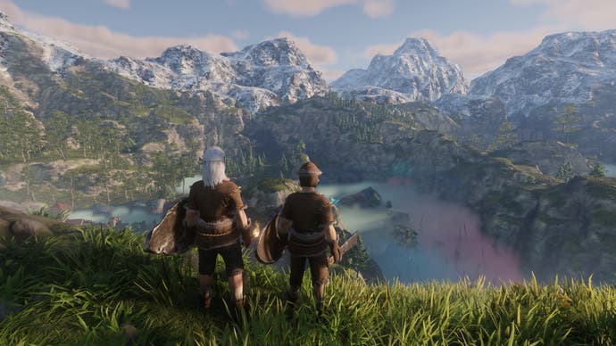 Enshrouded screenshot showing Two characters stand on the top of a hill, looking down on a wide vista with foggy valleys in the foreground and snowy mountains in the background.
