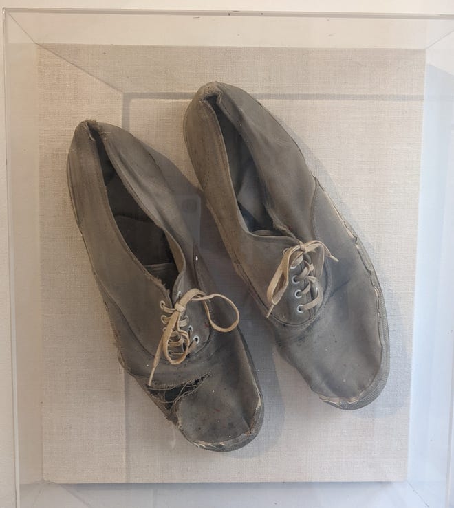 Two shoes with laces in an acrylic clear box
