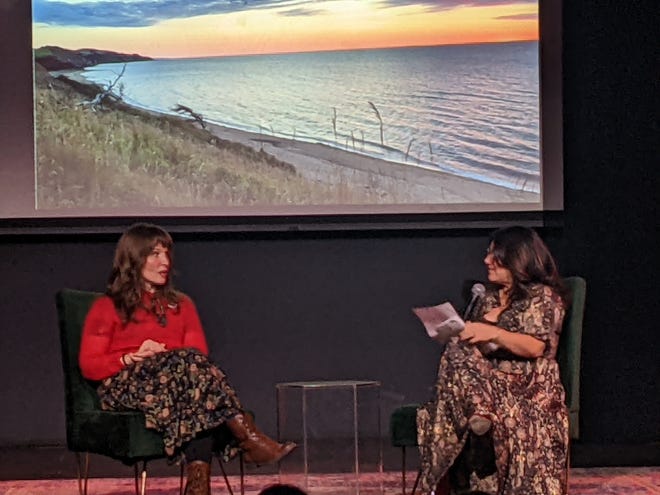 Kate Beaton (left) sitting in a chair with Carina Chocano (right) holding a microphone