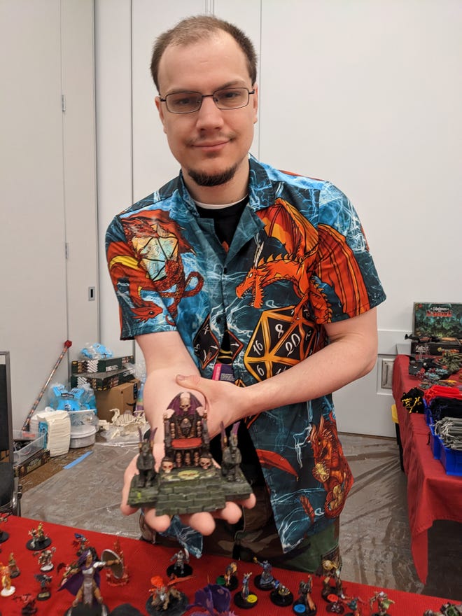 Photograph of Jonathan Gelotte holding a painted miniature