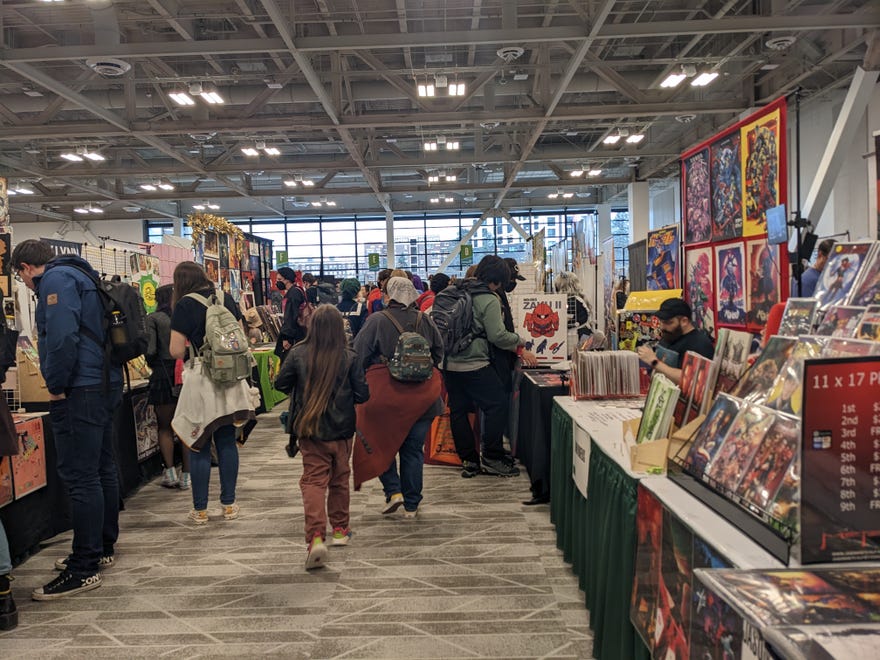 Photograph of artists alley featuring a busy group looking at different booths