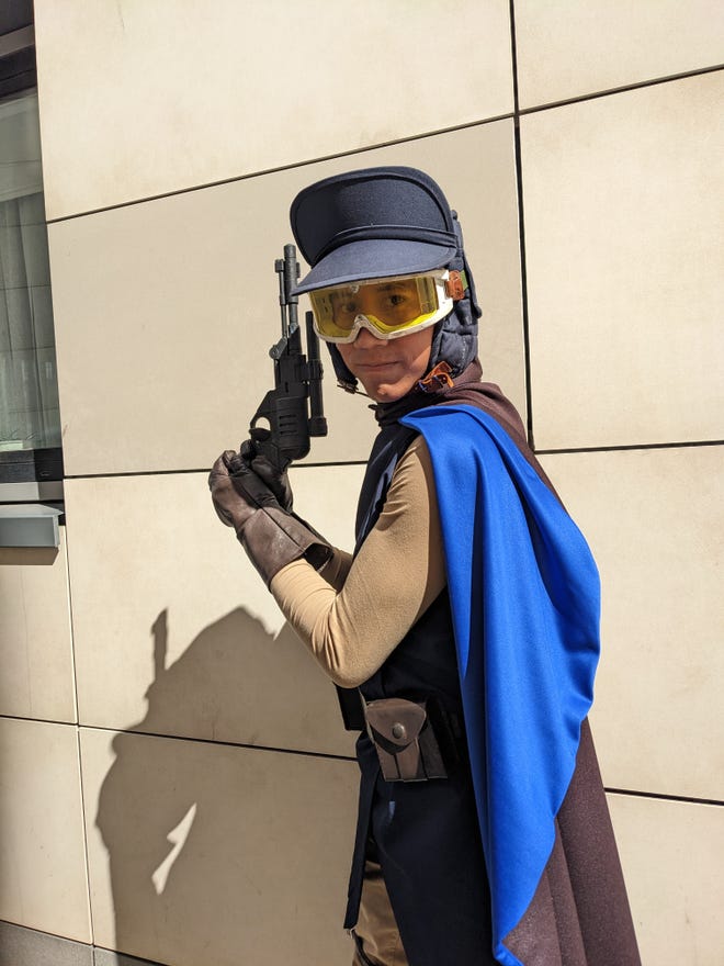 A photograph of a cosplayer holding a blaster