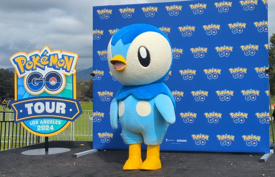 Photograph of Piplup in front of step and repeat