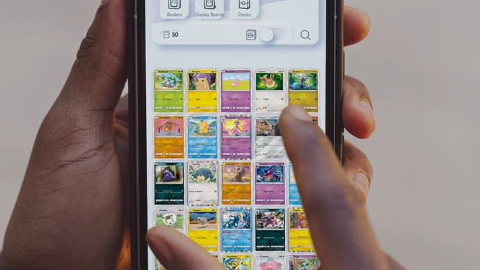 Pokemon Trading Card Game Pocket مجموعه ای از کارت هایی که روی صفحه موبایل نگه داشته شده را نشان می دهد