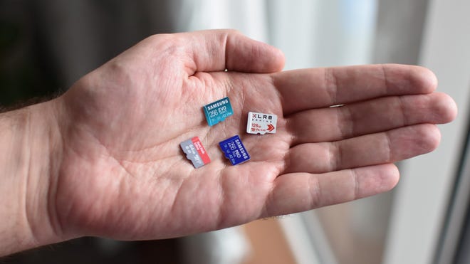 Various microSD cards in someone's hand.