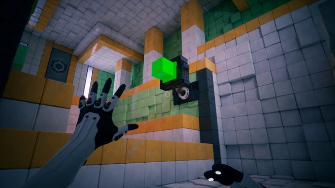 A gloved hand reaches toward a green cube dispenser in QUBE: 10th Anniversary