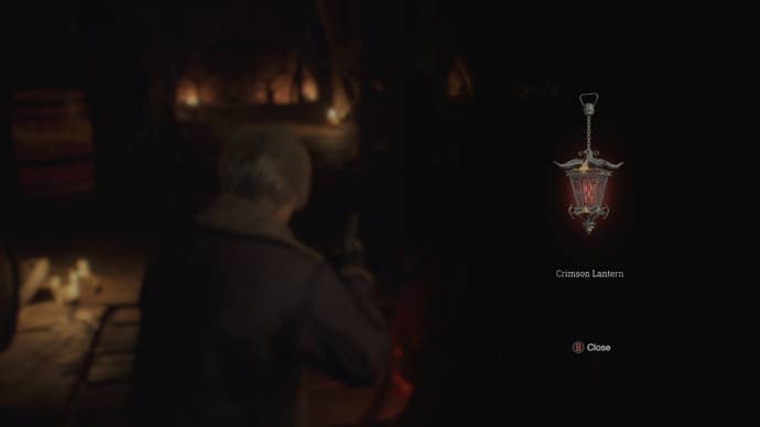 Leon retrieves the Crimson Lantern from a corpse in Resident Evil 4 Remake