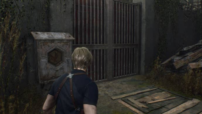 Leon looks at a gate that requires a hexagonal emblem to unlock in Resident Evil 4 Remake