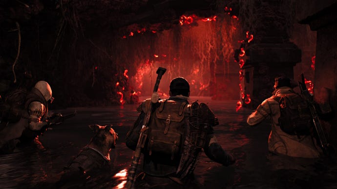 Three gunners walk into a dark, red cave in Remnant 2