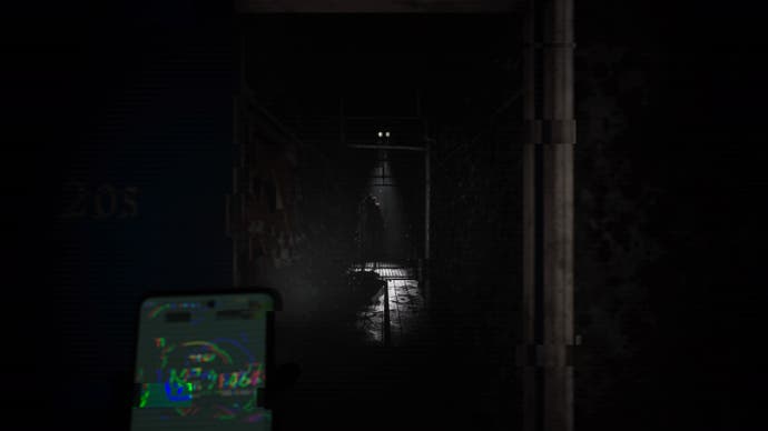 Silent Hill The Short Message Screenshot. At the end of a dark corridor stands a strange creature. Though half-obscured in darkness, it looks like the hair is made of flowers or a bush.
