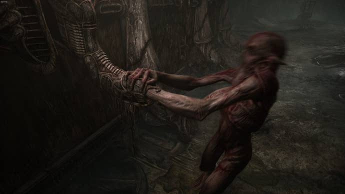 A creature puts their arm inside a rather phallic looking pillar in Scorn's Act 1