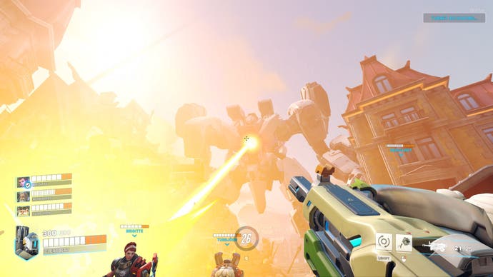 A screenshot from an Overwatch 2 story mission. The viewer sees from Bastion's perspective as a giant robot, towering out of the water, unleashes a beam of energy from its chest down towards the characters.