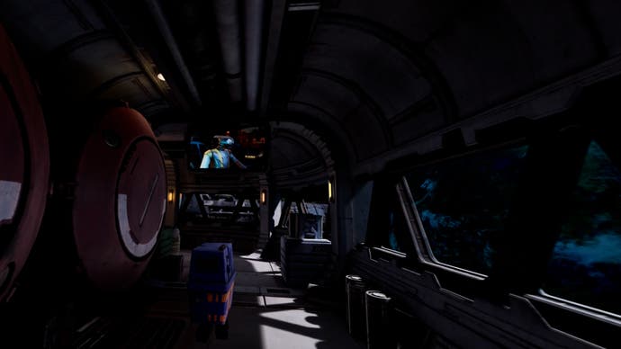 PSVR2 review - inside a metallic vehicle with a screen up ahead with a robot on it, and large containers to the left