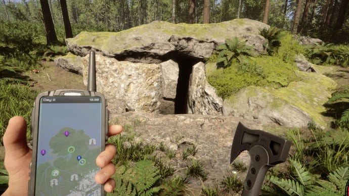Un jugador mira la entrada de una cueva mientras sostiene un GPS y un hacha en Sons of the Forest.