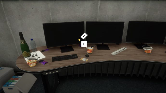 A player stares at a keycard on a desk by some screens in Sons of the Forest.